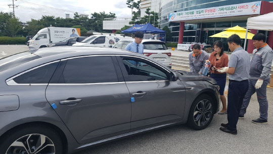 르노삼성자동차는 한국소비자원이 주관하는 '찾아가는 소비자 피해예방 교육 및 이동상담' 활동에 참여해 차량 무상점검 서비스를 제공했다고 25일 밝혔다. 사진은 르노삼성 직원으로부터 차량 점검을 받고 있는 차주의 모습. <르노삼성자동차 제공>